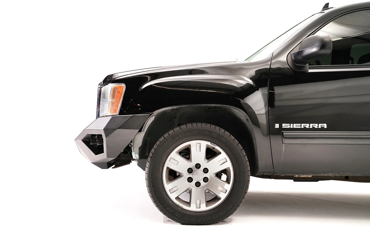 Fab Fours Vengeance front bumper on a black and gray GMC Sierra 1500, close-up of the front corner, showing angular end cap, bumper profile, wheel-well clearance