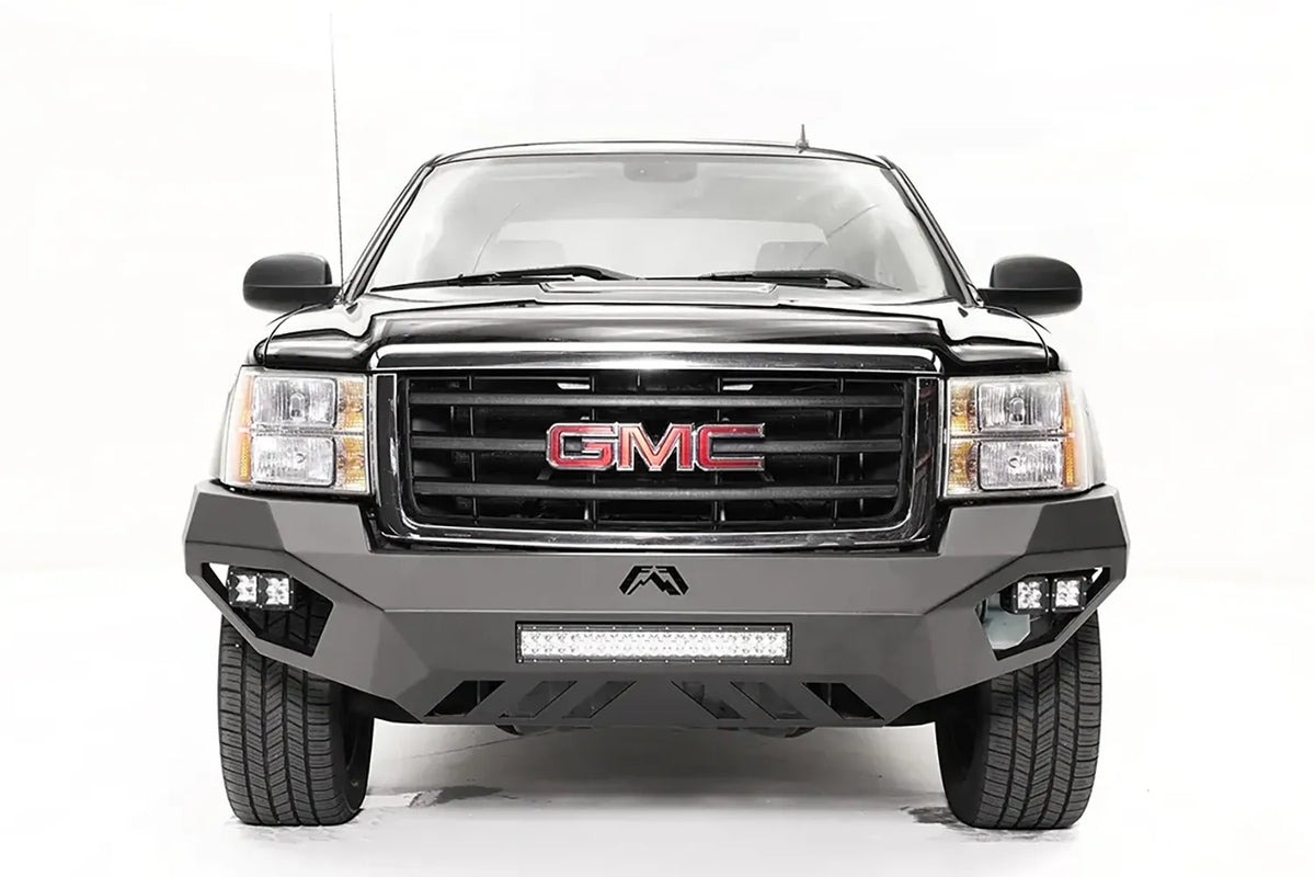 Fab Fours Vengeance front bumper on a black and gray GMC Sierra 1500, straight-on front view, showing integrated light bar, cube light pods, angular skid plate