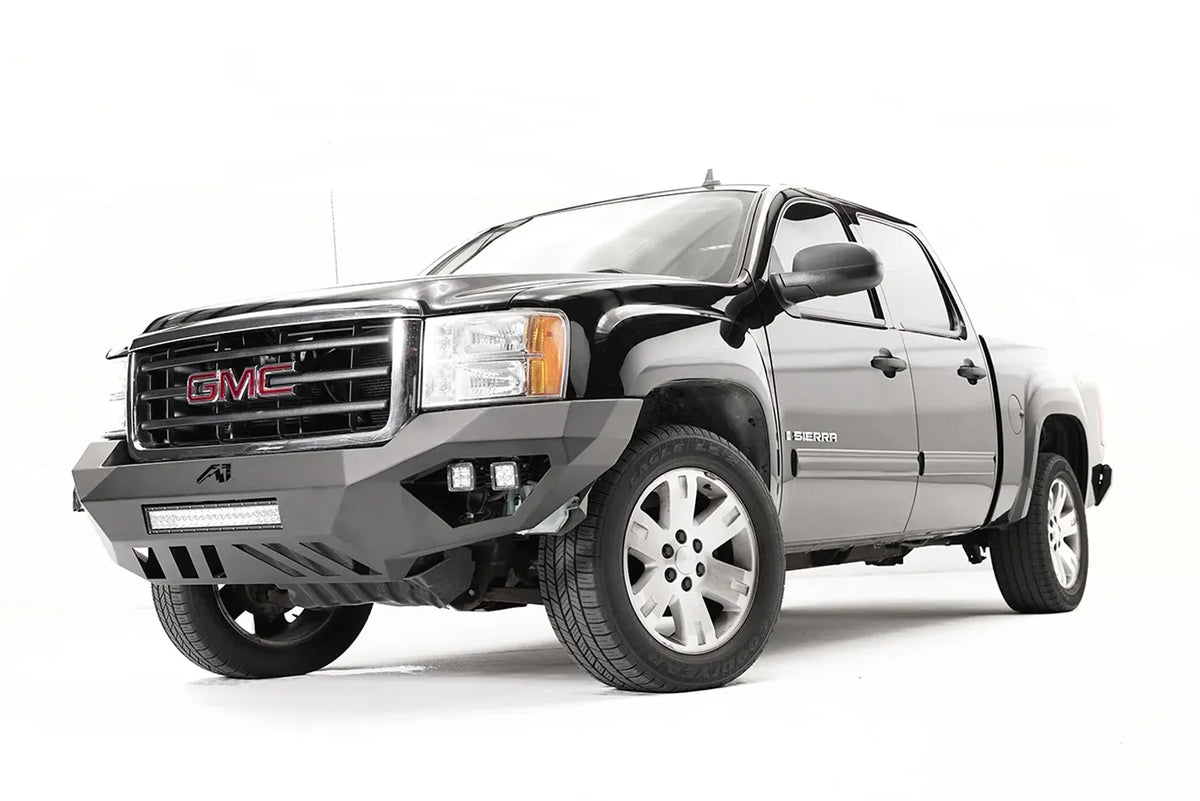 Fab Fours Vengeance front bumper on a black and gray GMC Sierra 1500, straight-on front view, showing integrated light bar, cube light pods, angular skid plate
