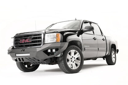 Fab Fours Vengeance front bumper on a black and gray GMC Sierra 1500, straight-on front view, showing integrated light bar, cube light pods, angular skid plate