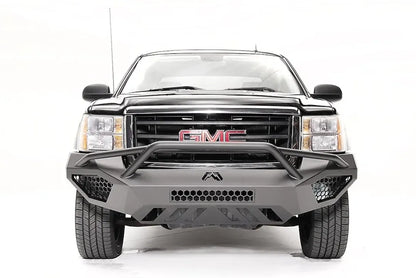 Fab Fours Vengeance front bumper with pre-runner guard on a black and gray GMC Sierra 1500, straight-on front view, showing pre-runner hoop, honeycomb mesh inserts, angular skid plate