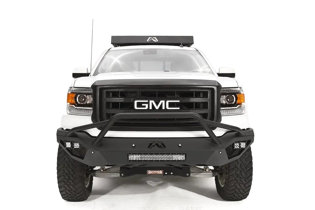 Fab Fours Vengeance front bumper with pre-runner guard on a white GMC Sierra 1500, straight-on front view, showing pre-runner hoop, integrated light bar, cube light pods