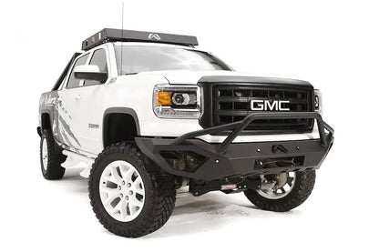 Fab Fours Vengeance front bumper with pre-runner guard on a white GMC Sierra 1500, straight-on front view, showing pre-runner hoop, integrated light bar, cube light pods