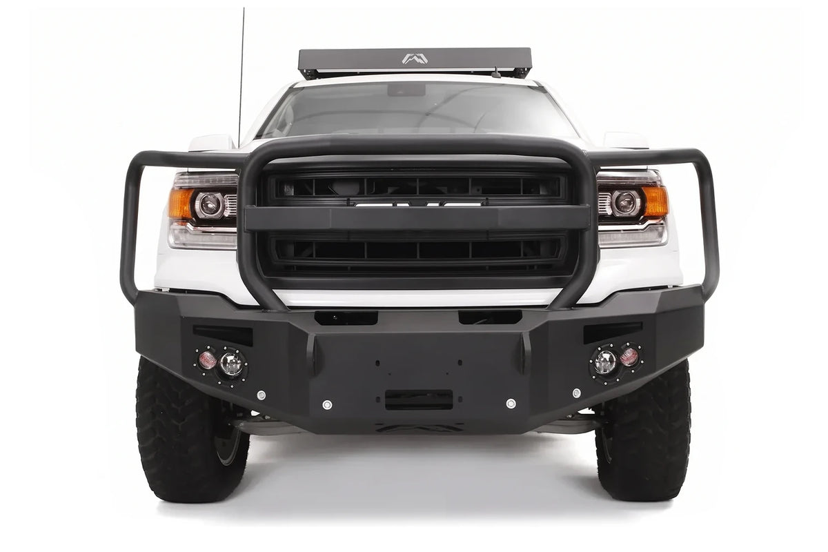 Fab Fours Premium heavy duty winch front bumper with full grille guard on a white GMC Sierra 1500