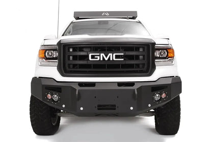 Fab Fours Premium Heavy Duty Winch front bumper on a white GMC Sierra 1500, straight-on front view, showing winch plate, round fog light pods, squared end caps
