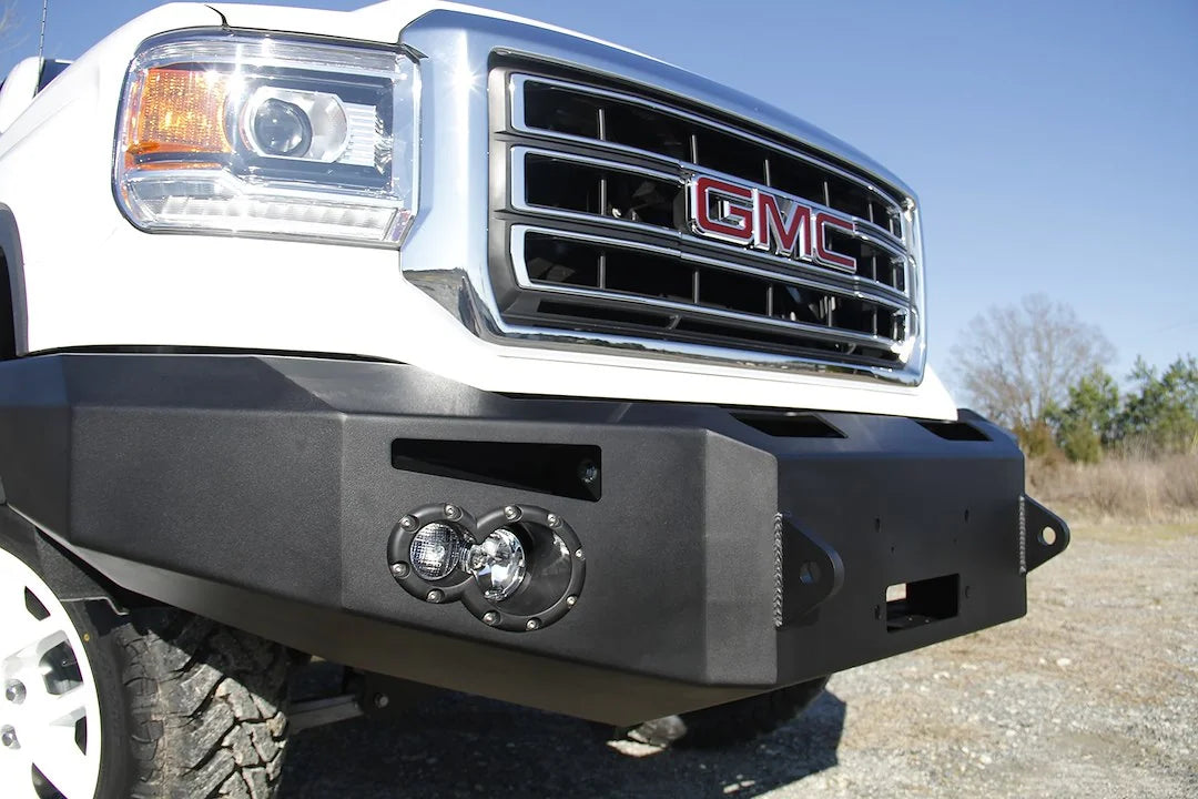Fab Fours Premium Winch front bumper on a white GMC Sierra 1500, straight-on front view, showing winch plate, round fog light pods, squared end caps
