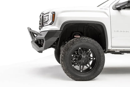Fab Fours Vengeance front bumper with pre-runner guard on a white GMC Sierra 1500, close-up of the front corner, showing the pre-runner tube, angled end cap and wheel clearance