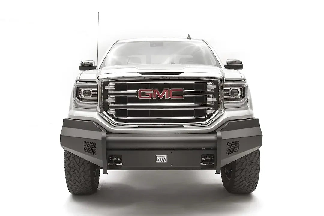 Fab Fours Black Steel Elite front bumper on a white GMC Sierra 1500, straight-on front view, showing the smooth plate bumper face, mesh vent openings and light cutouts