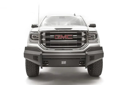 Fab Fours Black Steel Elite front bumper on a white GMC Sierra 1500, straight-on front view, showing the smooth plate bumper face, mesh vent openings and light cutouts