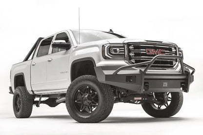 Fab Fours Black Steel Elite front bumper with pre-runner guard on a white GMC Sierra 1500, passenger-side front three-quarter view, showing the pre-runner hoop, smooth plate bumper face and mesh vent openings