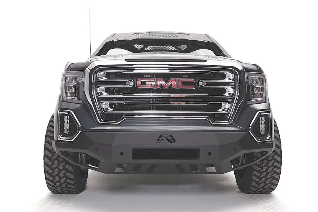 Fab Fours Vengeance front bumper on a dark gray GMC Sierra 1500, straight-on front view, showing the angular bumper face, center light bar opening and lower skid plate