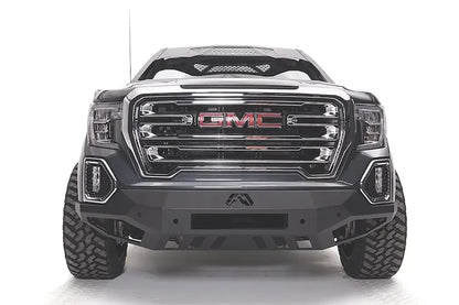 Fab Fours Vengeance front bumper on a dark gray GMC Sierra 1500, straight-on front view, showing the angular bumper face, center light bar opening and lower skid plate