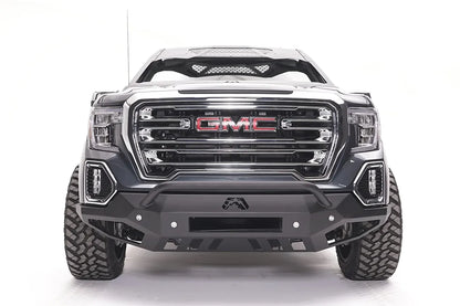 Fab Fours Vengeance front bumper with pre-runner guard on a dark gray GMC Sierra 1500, straight-on front view, showing the low pre-runner bar, center light bar opening and lower skid plate
