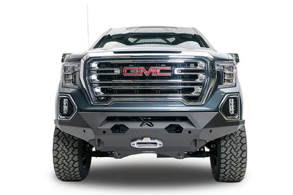 Fab Fours Matrix front bumper on a dark gray GMC Sierra 1500, straight-on front view, showing the winch fairlead opening, cutout bumper face and lower skid plate
