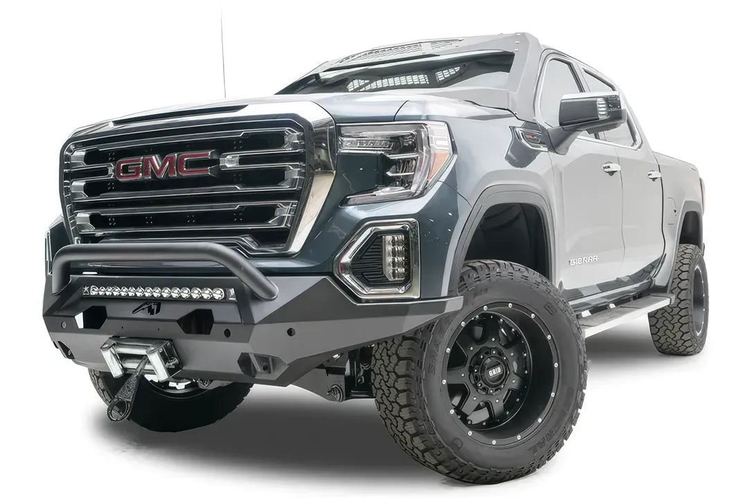 Fab Fours Matrix front bumper with pre-runner guard on a dark gray GMC Sierra 1500, driver-side front three-quarter view, showing the pre-runner bar, light bar opening and winch fairlead