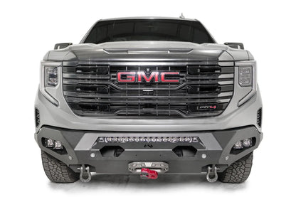 Fab Fours Matrix front bumper on a silver GMC Sierra 1500, straight-on front view, showing the center light bar, winch fairlead and D-ring shackle mounts