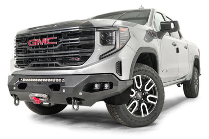 Fab Fours Matrix front bumper on a silver GMC Sierra 1500, driver-side front three-quarter view, showing the light bar opening, winch fairlead and D-ring shackle mounts