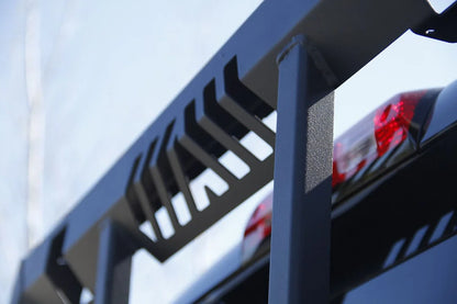 Fab Fours headache rack on a dark pickup, close-up outdoors, showing the slotted top rail vents, square tube upright and black powder coat finish