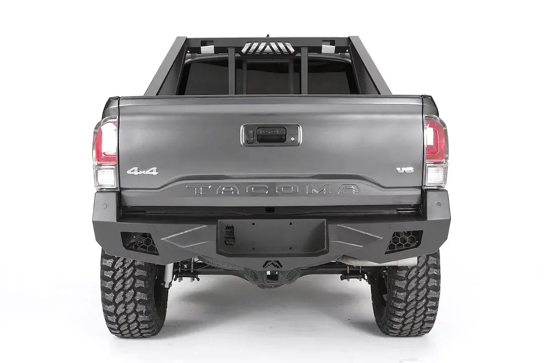 Fab Fours headache rack on a gray Toyota Tacoma, rear view, showing the vertical bars and slotted brake light vent above the tailgate