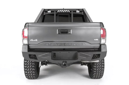 Fab Fours headache rack on a gray Toyota Tacoma, rear view, showing the vertical bars and slotted brake light vent above the tailgate