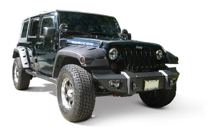 Fab Fours Lifestyle Winch bumper on a dark blue Jeep Wrangler JK Rubicon, passenger-side front three-quarter view outdoors, showing the bumper face, fog lights and end caps