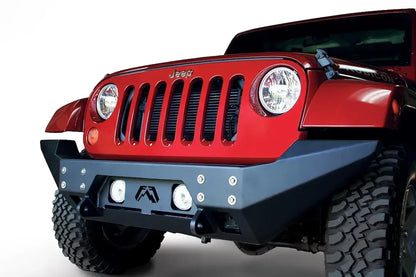 Fab Fours Full Metal Jacket full-width front bumper on a red Jeep Wrangler JK, front three-quarter close-up, showing the bolted face plate, round fog lights and full-width end caps