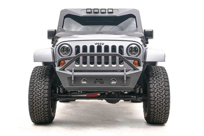 Fab Fours Stubby bumper with pre-runner guard on a silver Jeep Wrangler JK, straight-on front view, showing the pre-runner hoop, fog light openings and Fab Fours logo cutout