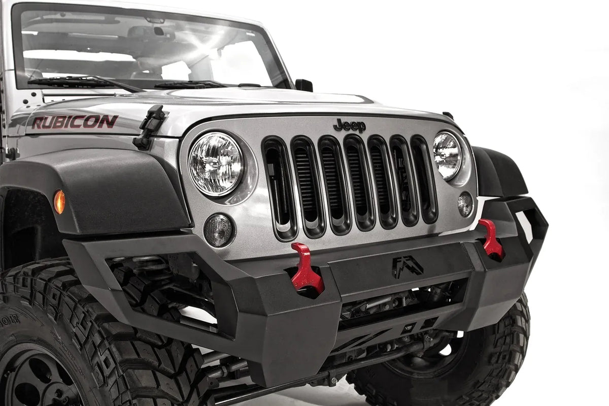 Fab Fours Vengeance front bumper on a silver Jeep Wrangler JK Rubicon, close-up of the front, showing the angular bumper face, red shackles and wrapped end cap