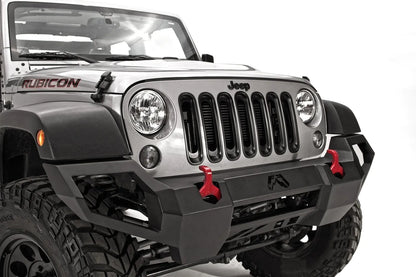 Fab Fours Vengeance front bumper on a silver Jeep Wrangler JK Rubicon, close-up of the front, showing the angular bumper face, red shackles and wrapped end cap