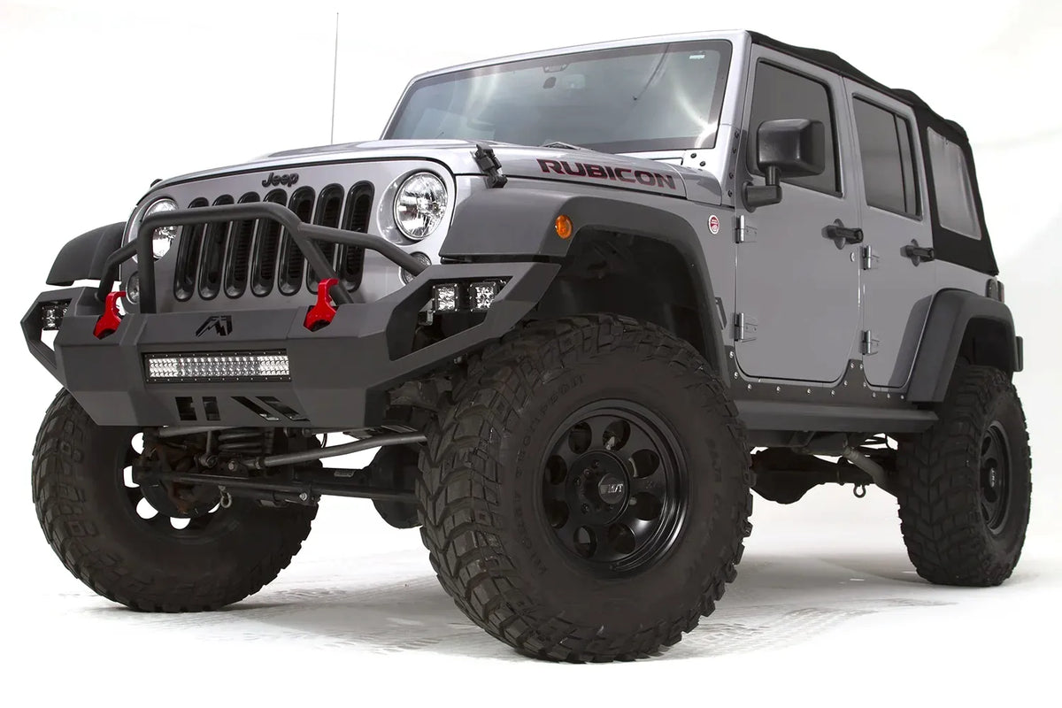 Fab Fours Vengeance front bumper with pre-runner guard on a silver Jeep Wrangler JK Rubicon, driver-side front three-quarter view, showing the pre-runner hoop, center light bar and pod lights