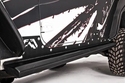 Fab Fours HardCore Rock Sliders on a black and white Jeep Wrangler JK, close-up of the rocker, showing the tubular slider rail, riveted rocker plate and Fab Fours logo cutout