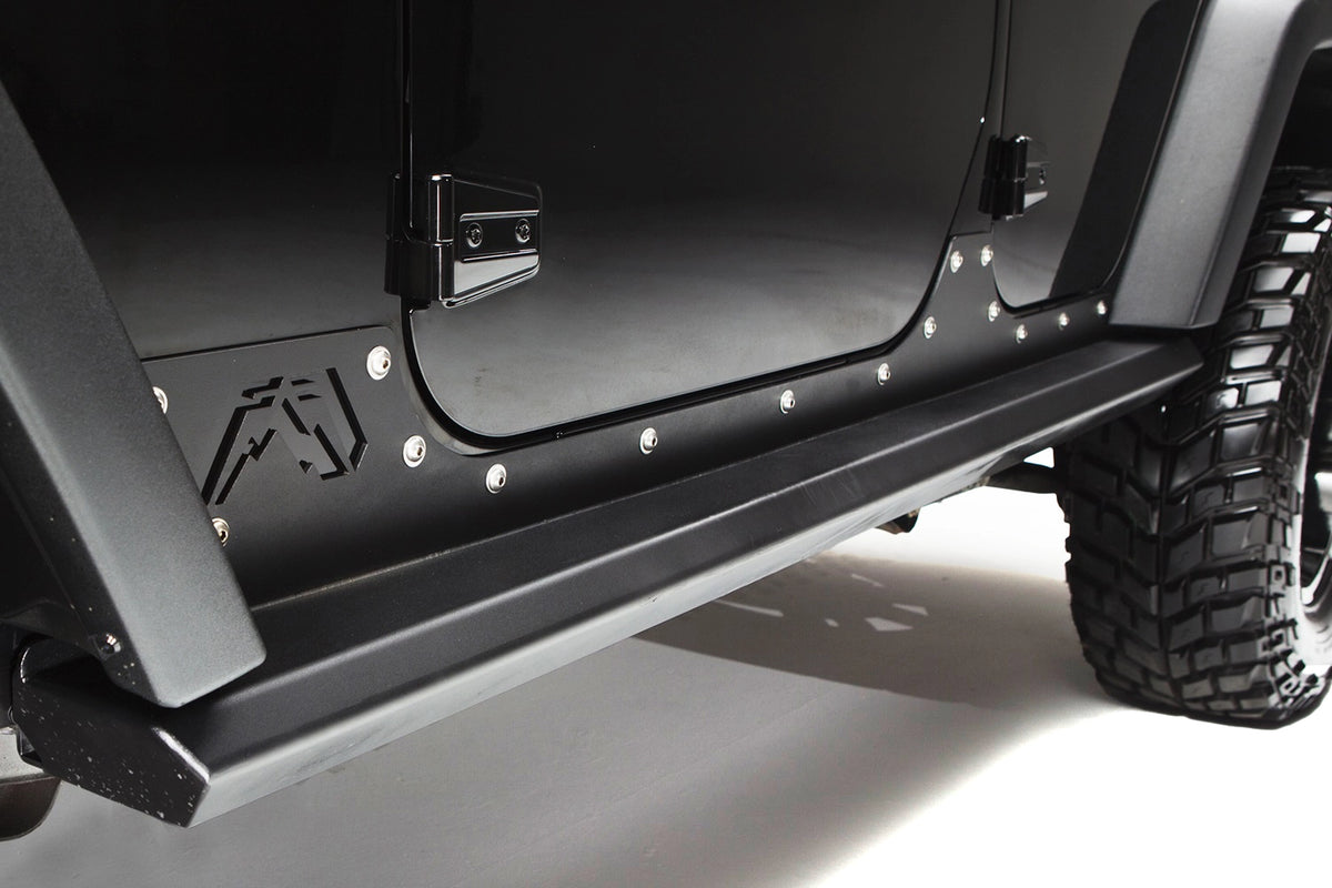 Fab Fours HardCore Rock Sliders on a black Jeep Wrangler JK, close-up of the rocker, showing the tubular slider rail, riveted rocker plate and Fab Fours logo cutout