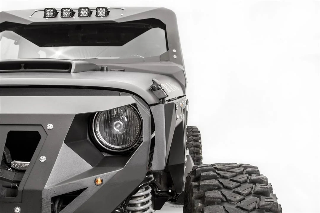 Close-up of Fab Fours front steel fender beside the headlight on the driver side of a black Jeep Wrangler JK