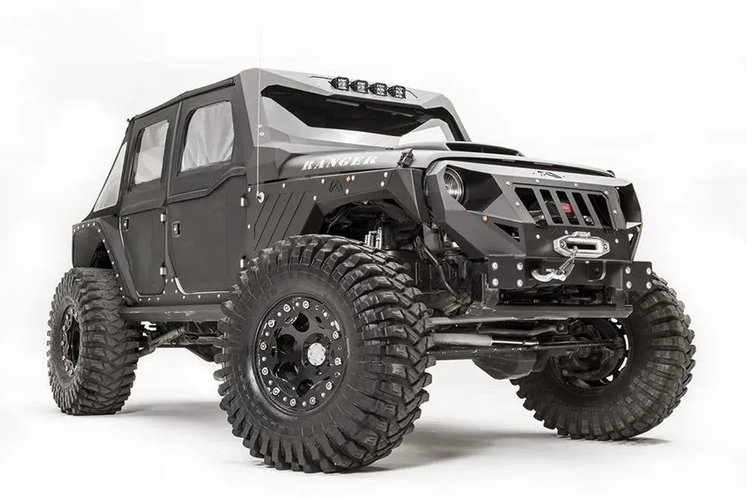 Fab Fours front steel fenders on a lifted black Jeep Wrangler JK Unlimited, passenger-side front three-quarter view, with Fab Fours grille guard and winch