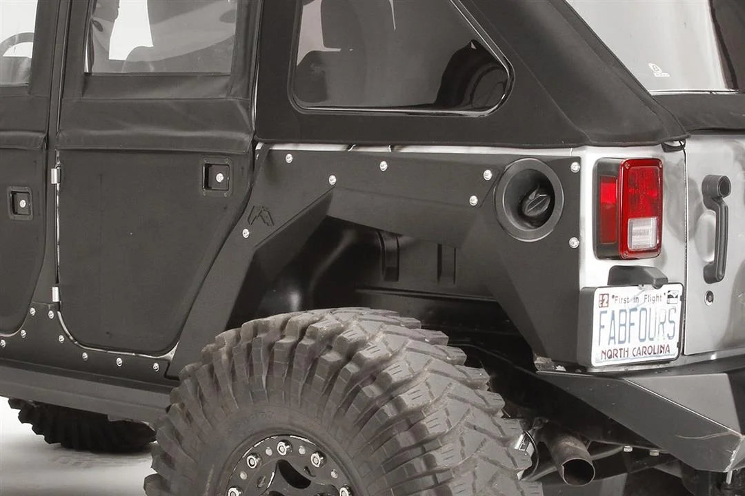 Fab Fours rear fender base on a black 4-door Jeep Wrangler JK, close-up of the rear corner, showing the riveted rear fender panel, fuel door cutout and Fab Fours logo