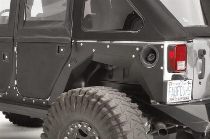 Fab Fours rear fender base on a black 4-door Jeep Wrangler JK, close-up of the rear corner, showing the riveted rear fender panel, fuel door cutout and Fab Fours logo