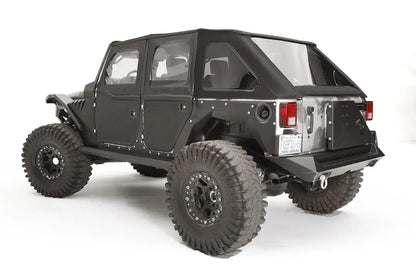 Fab Fours rear fender base on a black 4-door Jeep Wrangler JK, rear driver-side three-quarter view, showing the riveted rear fender panel, exposed wheel well and fuel door cutout