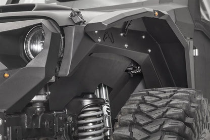 Fab Fours front inner fender and fender flare on the driver side of a black Jeep Wrangler JK, next to the headlight, with amber marker light and Fab Fours logo cutout