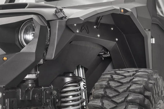 Fab Fours front inner fender and fender flare on the driver side of a black Jeep Wrangler JK, next to the headlight, with amber marker light and Fab Fours logo cutout
