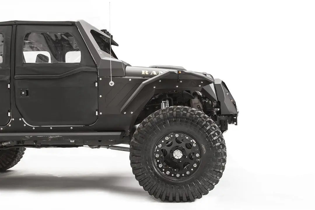 Fab Fours aggressive narrow front fender flare on a black Jeep Wrangler JK, passenger-side view, showing the riveted steel flare with marker light over a large off-road tire