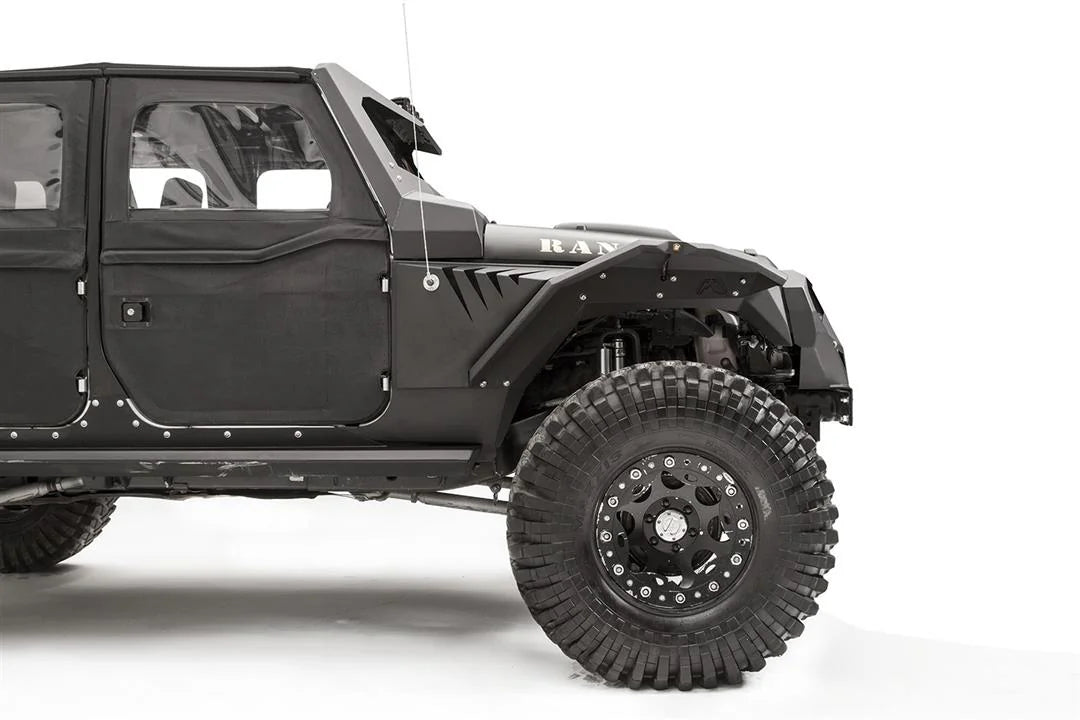 Fab Fours fender gill box behind the front fender flare on a lifted black Jeep Wrangler JK, passenger-side view of the front half