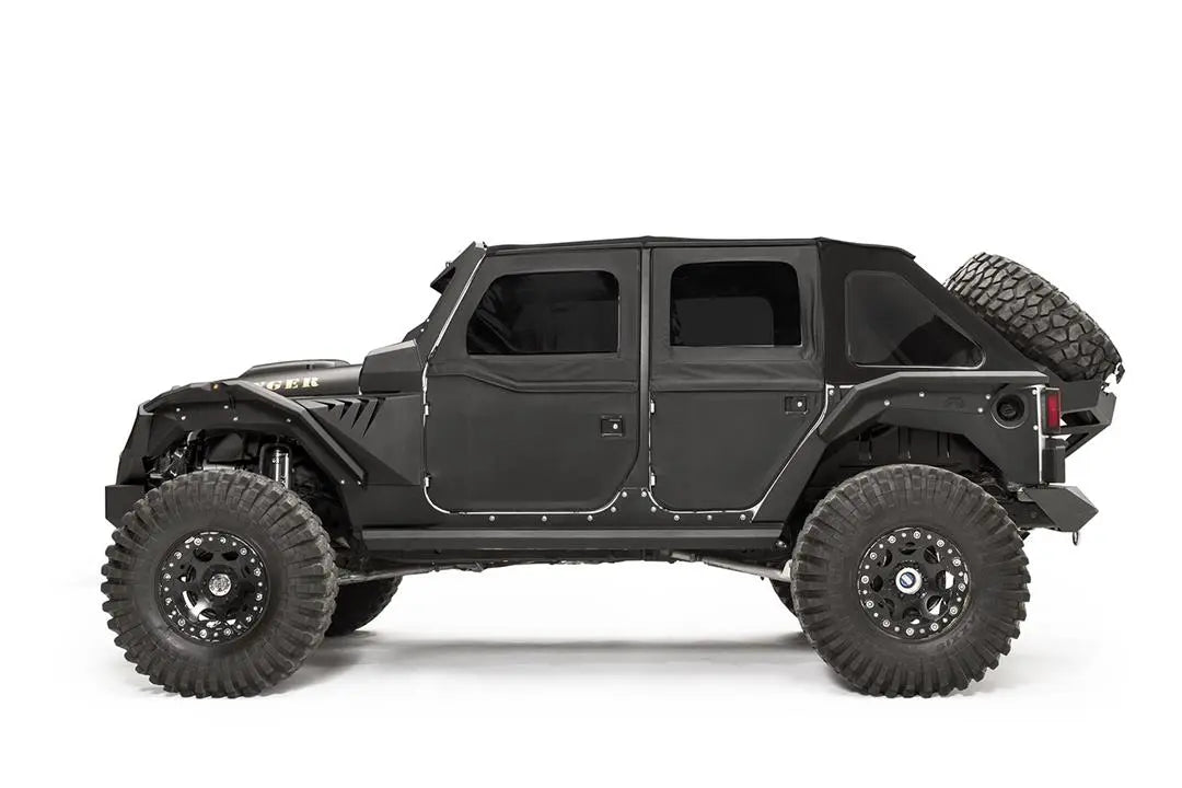 Fab Fours rear fender flare on a black 4-door Jeep Wrangler JK, driver-side profile view, showing the rear flare, wheel clearance and riveted body armor