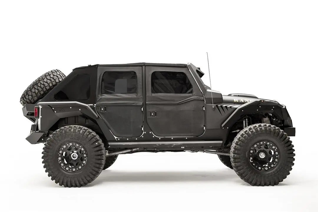Fab Fours rear fender flare on a black 4-door Jeep Wrangler JK, passenger-side profile view, showing the rear flare, front and rear wheel clearance and riveted body armor