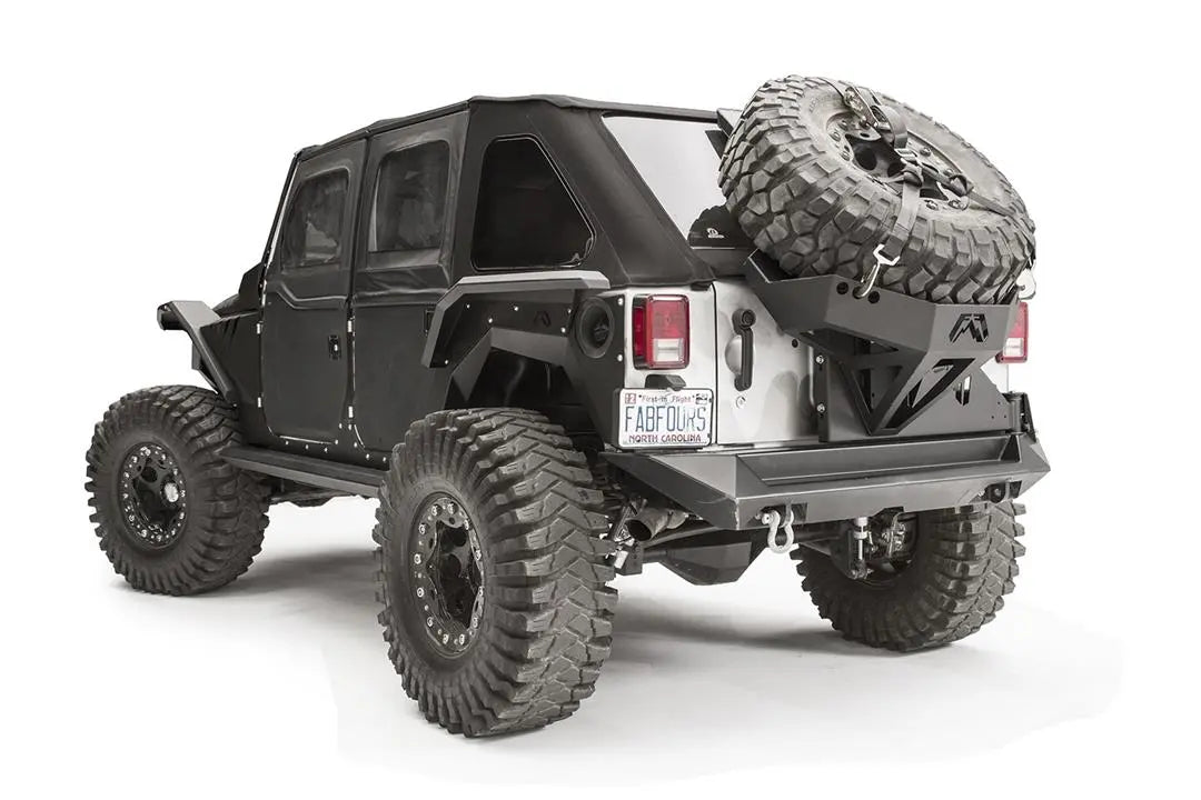 Fab Fours rear fender flare on a black 4-door Jeep Wrangler JK, rear driver-side three-quarter view, showing the high-clearance rear flare, riveted body armor and wheel clearance