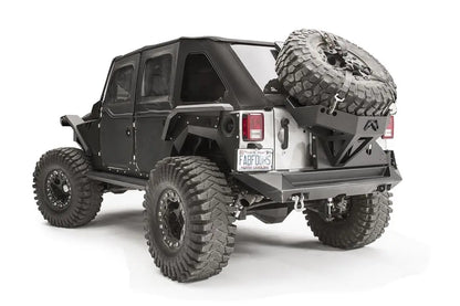Fab Fours rear fender flare on a black 4-door Jeep Wrangler JK, rear driver-side three-quarter view, showing the high-clearance rear flare, riveted body armor and wheel clearance