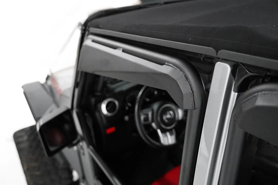 Fab Fours full tube door on a Jeep Wrangler JK, close-up of the front door's padded upper frame, showing the stitched black cover with the mirror and steering wheel behind