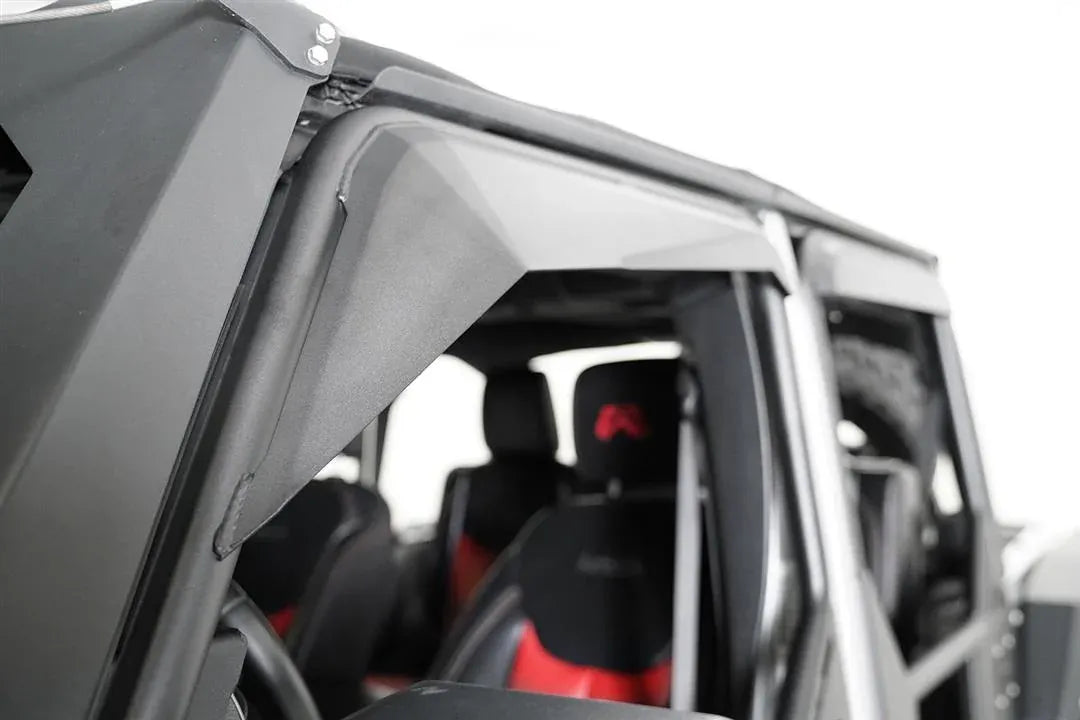 Fab Fours full tube door on a Jeep Wrangler JK, close-up of the padded upper window frame, showing the angled black cover over the tube with the interior and seats behind