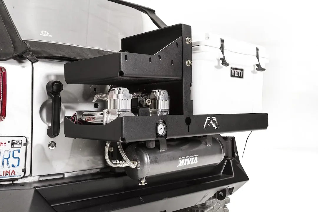 Close-up of the Fab Fours air compressor bracket, showing dual Viair 444C compressors, pressure gauge and air tank mounted beside a Yeti cooler