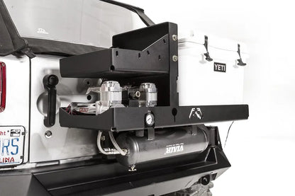 Close-up of the Fab Fours air compressor bracket, showing dual Viair 444C compressors, pressure gauge and air tank mounted beside a Yeti cooler