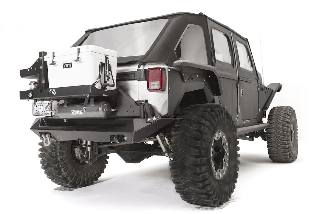 Fab Fours air compressor and Yeti Tundra 35 cooler mount on a Jeep Wrangler JK, rear passenger-side view, holding a white Yeti cooler above a Viair air tank on the tire carrier